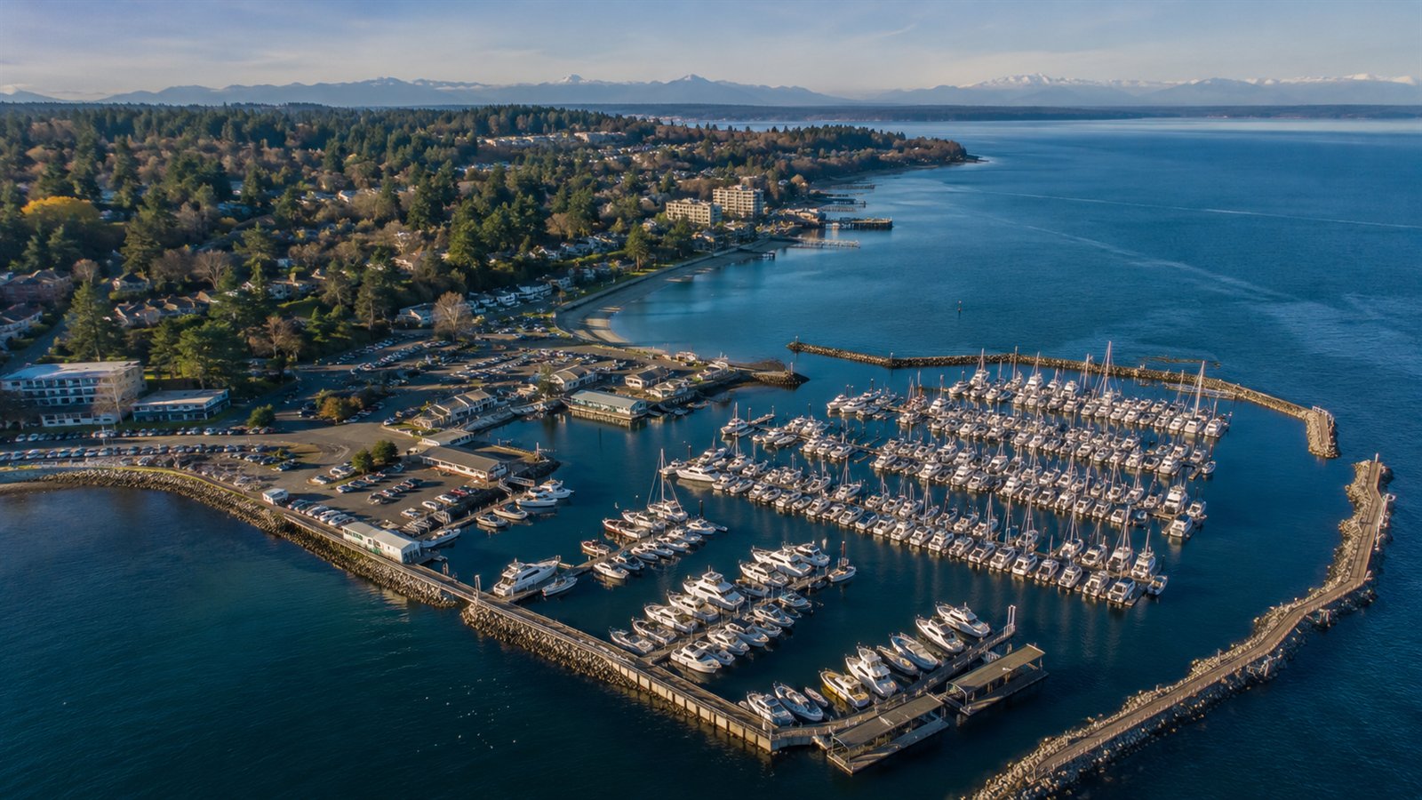 Aerial drone view of the Des Moines Marina on Puget Sound with the Olympic Mountains