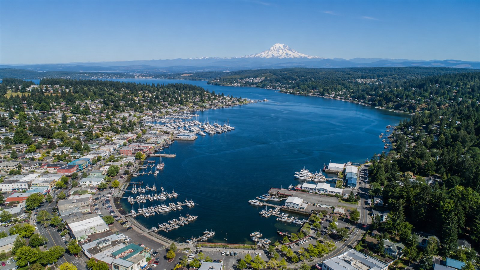 Aerial drone view of Gig Harbor bay full of boats with Mount Rainier in the distance